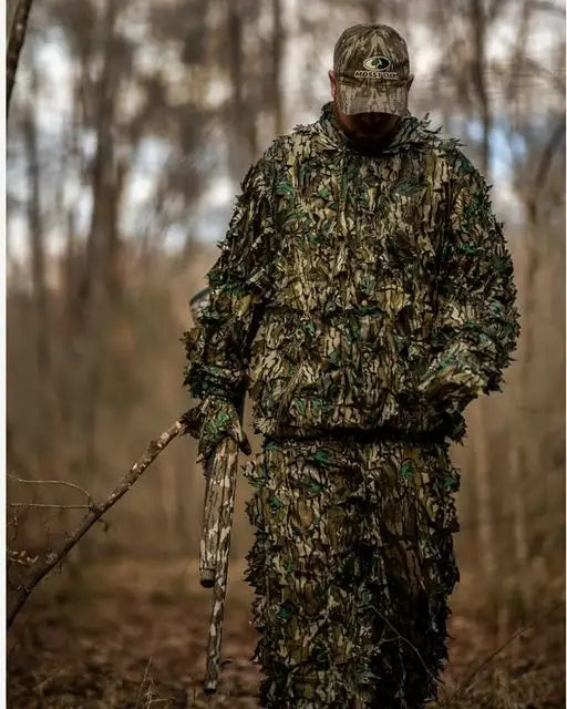 Hunter wearing a Titan 3D Mossy Oak Greenleaf leafy suit in woodland