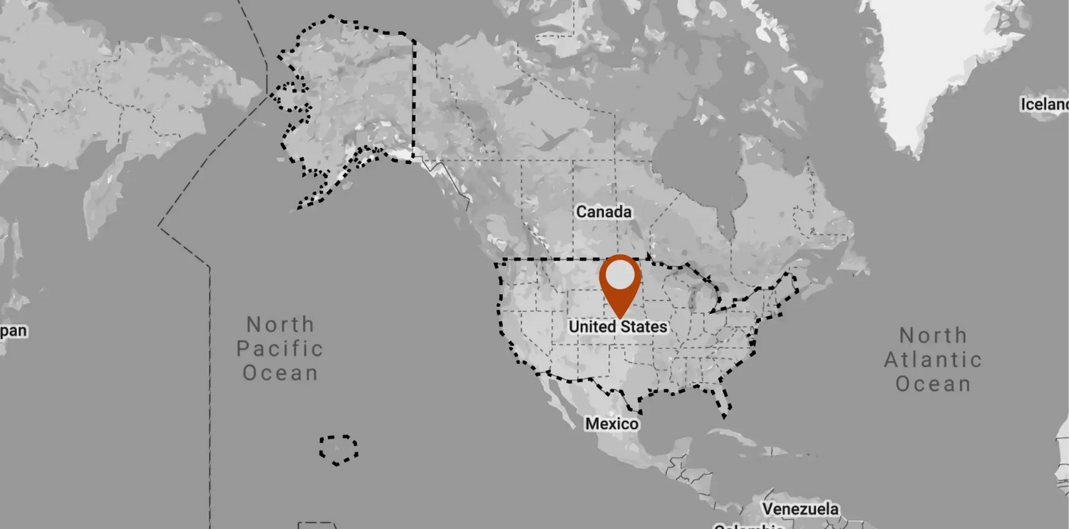 An orange location pin marking the united states on a grayscale world map.