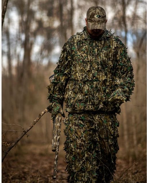 Hunter wearing a Titan 3D Mossy Oak Greenleaf leafy suit in woodland